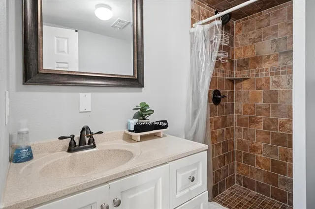 a bathroom with a sink a vanity and a shower