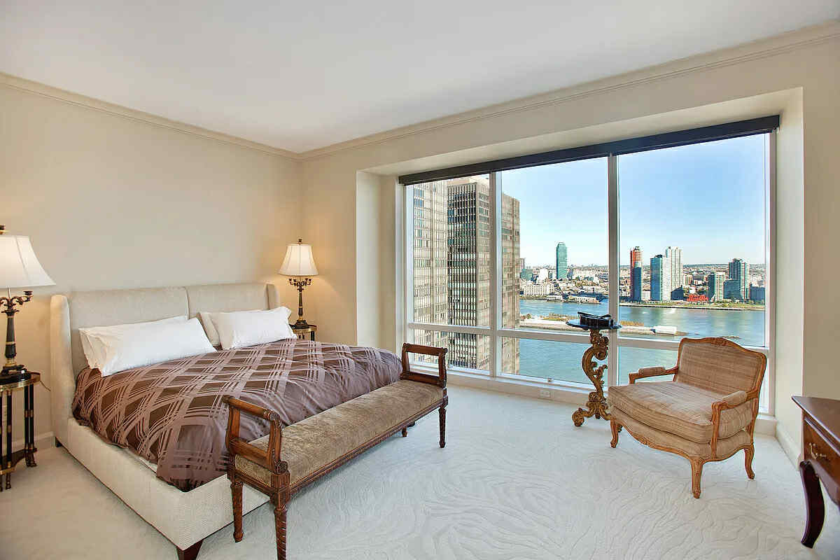 845 United Nations Plaza, Unit 32B Manhattan, NY 10017 - Photo 4 of 9 a bedroom with a bed and large windows