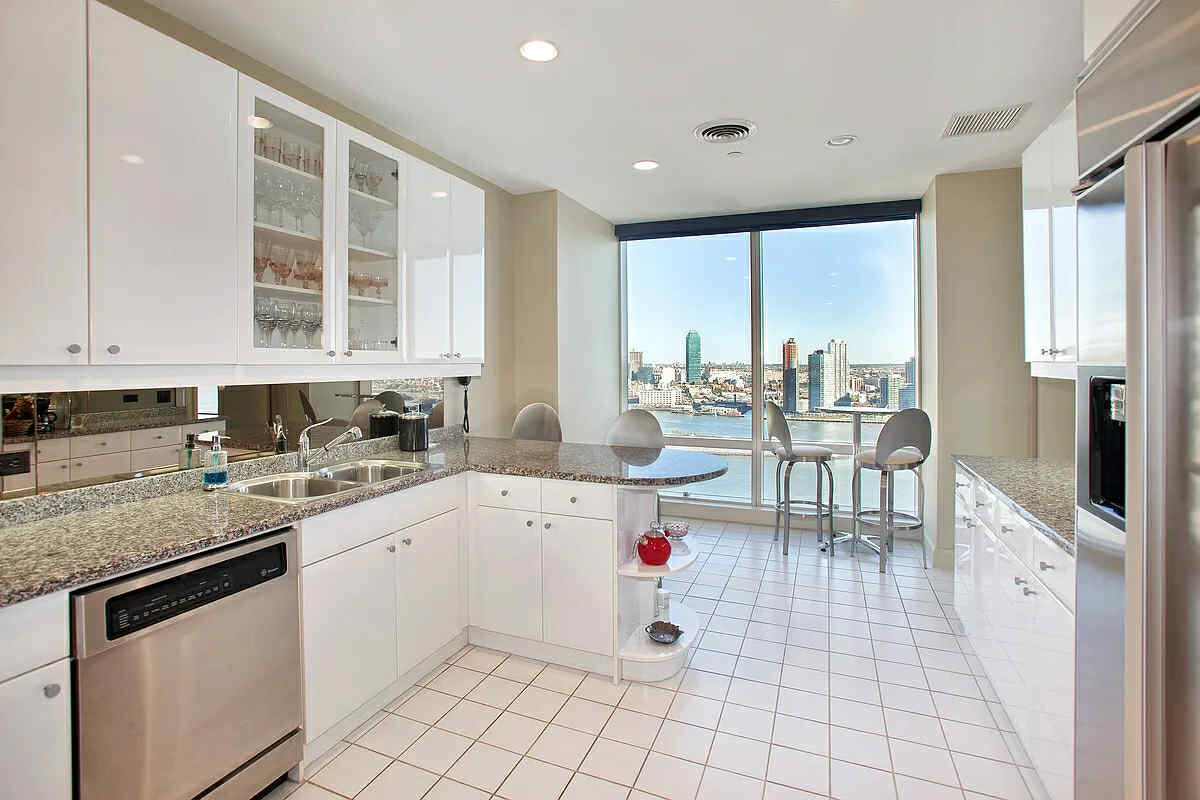 845 United Nations Plaza, Unit 32B Manhattan, NY 10017 - Photo 5 of 9 a kitchen with a sink stove and cabinets