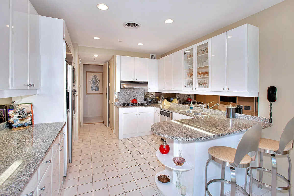 845 United Nations Plaza, Unit 32B Manhattan, NY 10017 - Photo 6 of 9 a kitchen with sink refrigerator and cabinets