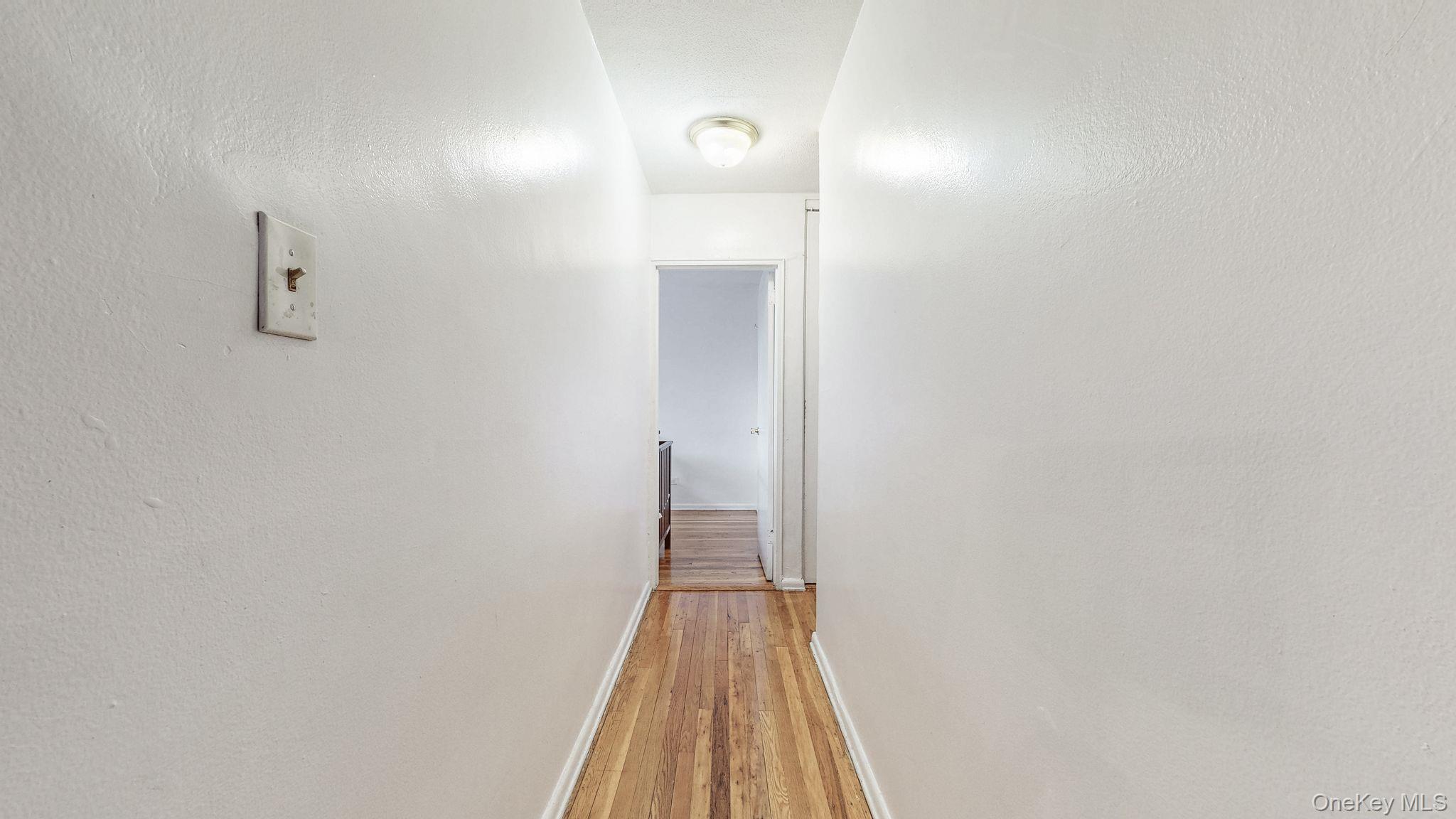 41-42 73rd Street, Unit 7J Queens, NY 11377 - Photo 3 of 8 a view of a hallway with wooden floor