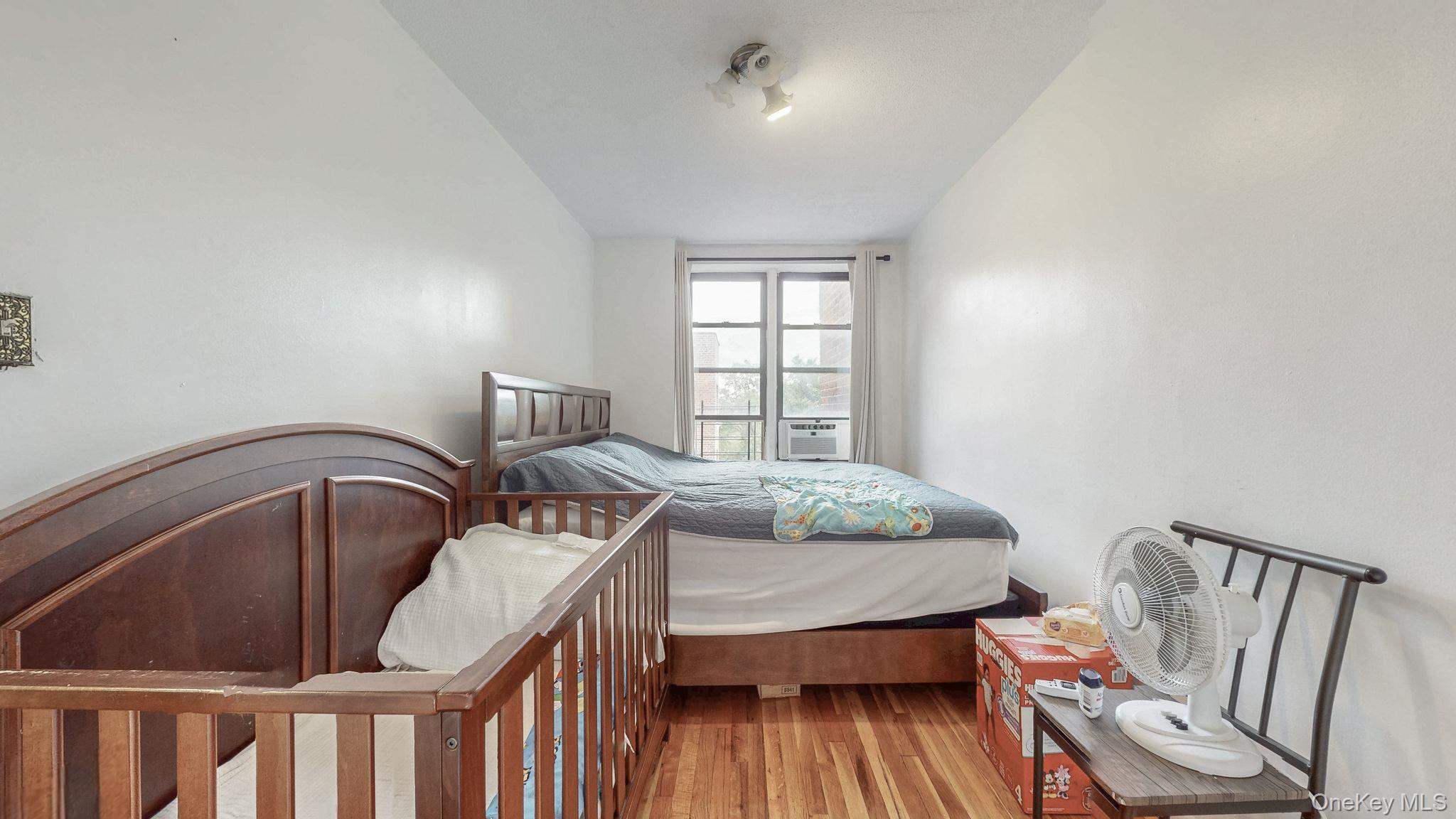 41-42 73rd Street, Unit 7J Queens, NY 11377 - Photo 7 of 8 a bedroom with furniture and wooden floor