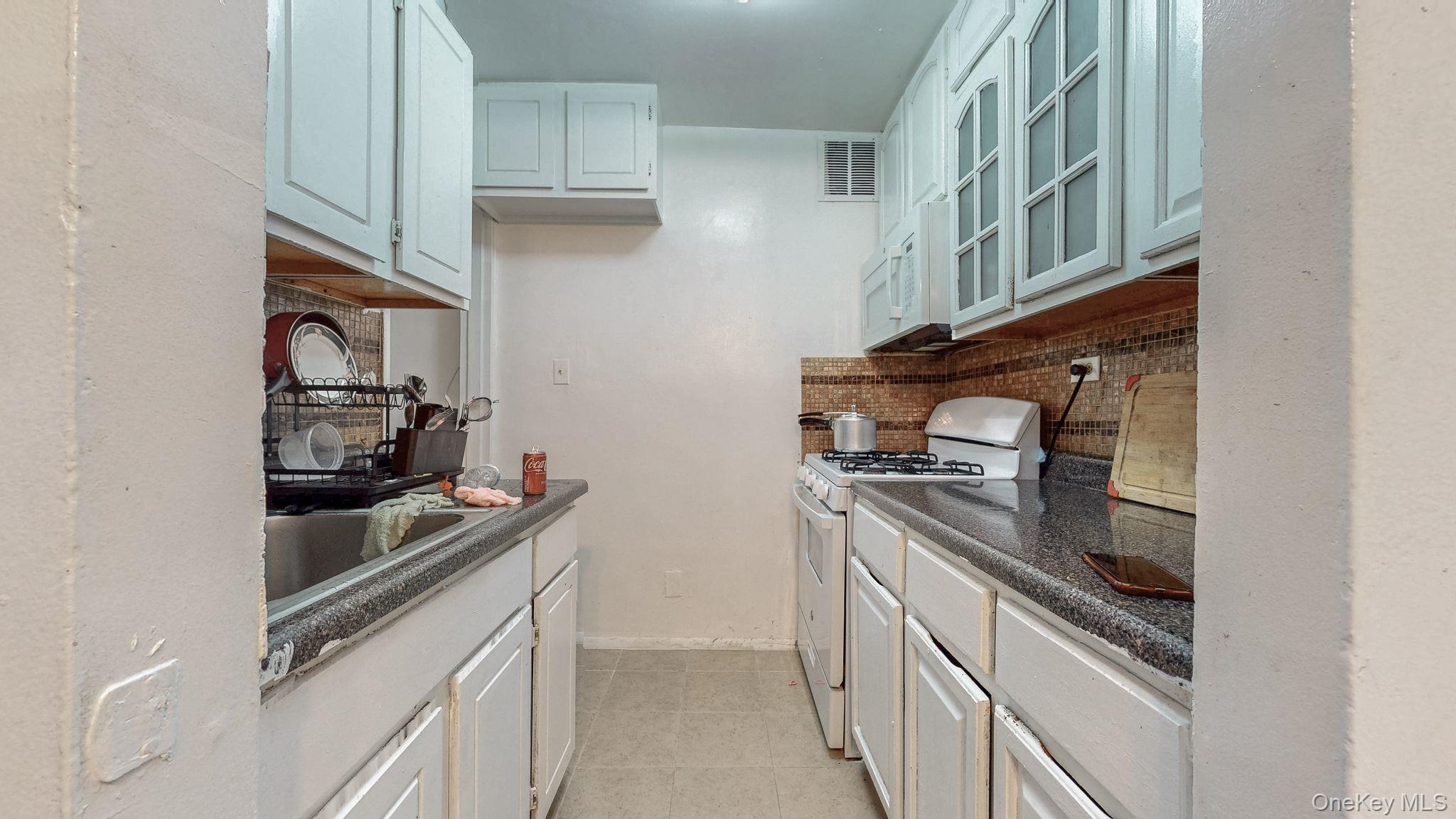41-42 73rd Street, Unit 7J Queens, NY 11377 - Photo 8 of 8 a kitchen with stainless steel appliances granite countertop a stove and a refrigerator