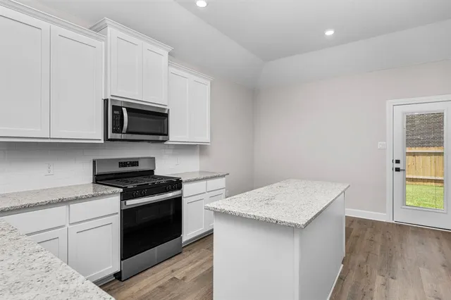 a kitchen with stainless steel appliances a stove microwave and sink