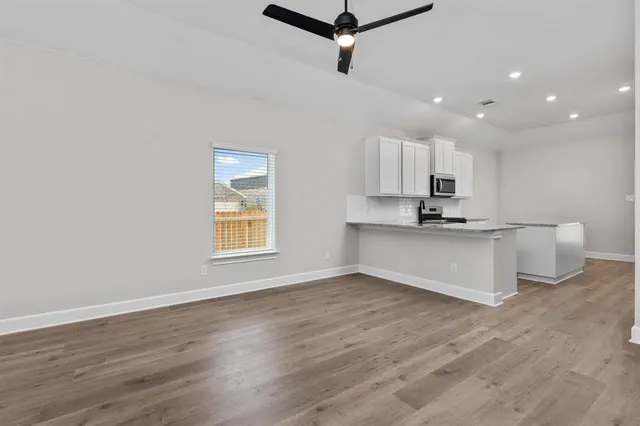 a view of kitchen with granite countertop cabinets and wooden floor