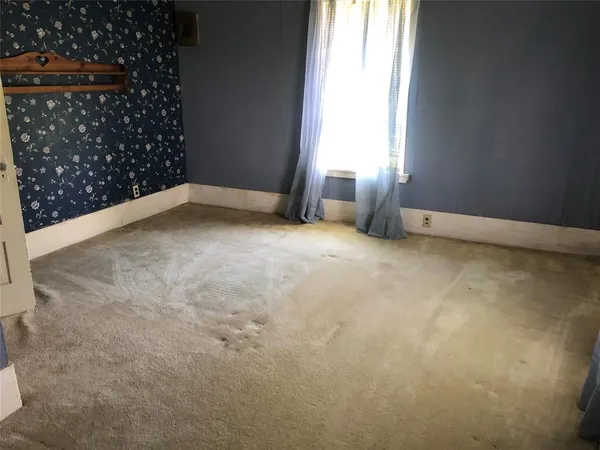 an empty room with fireplace and fan