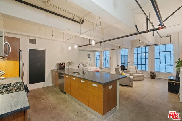 a kitchen with stainless steel appliances granite countertop a sink and a refrigerator