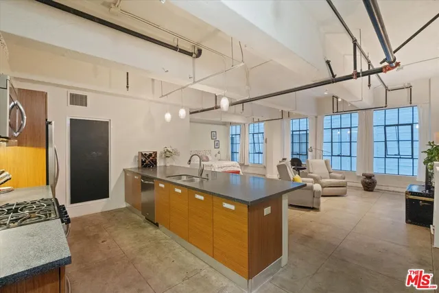 a kitchen with stainless steel appliances granite countertop a sink and a refrigerator