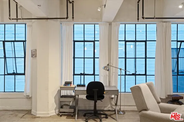 a view of a workspace with furniture and a window