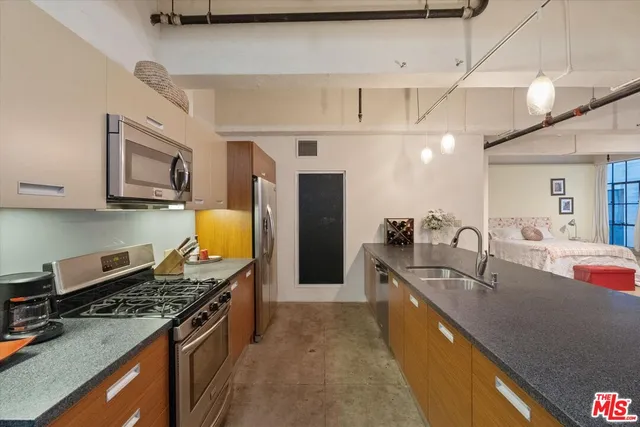 a large kitchen with stainless steel appliances granite countertop a lot of cabinets a stove and a sink