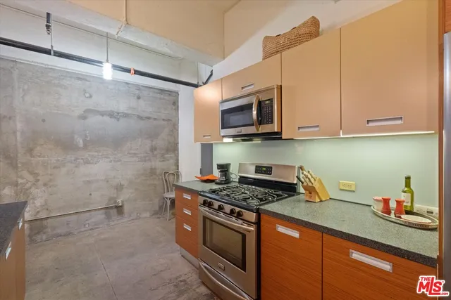 a kitchen with stainless steel appliances granite countertop a sink a stove and cabinets