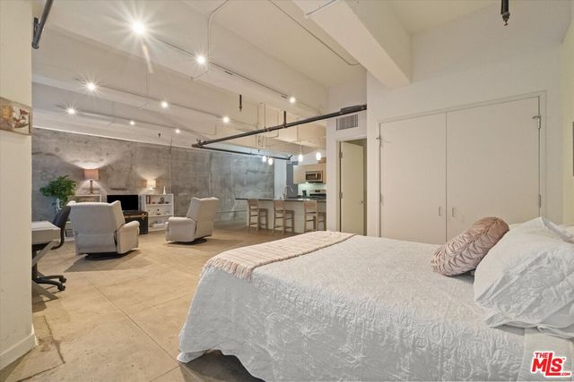 a bedroom with a bed and a large mirror