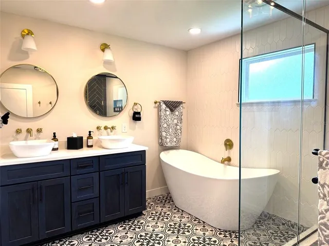 a bathroom with a double vanity sink a toilet a mirror and shower