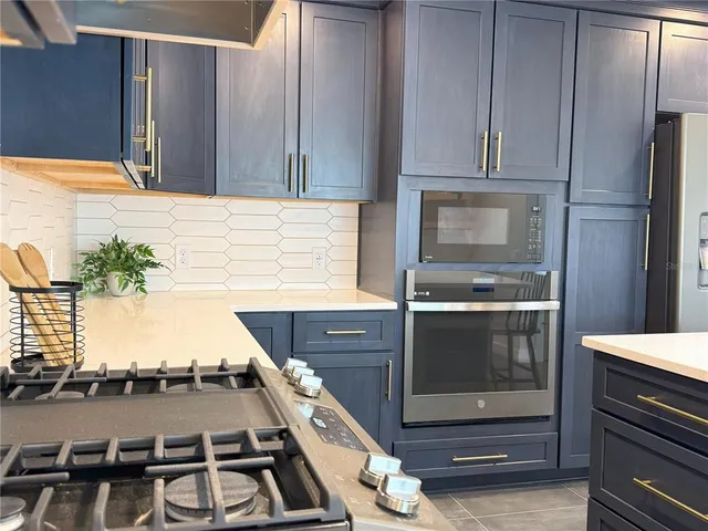 a view of a house with a yard and a large tree