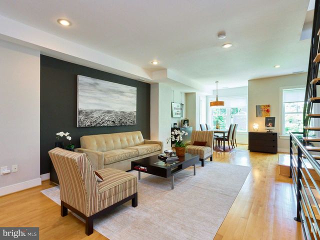 a living room with furniture wooden floor and a large window