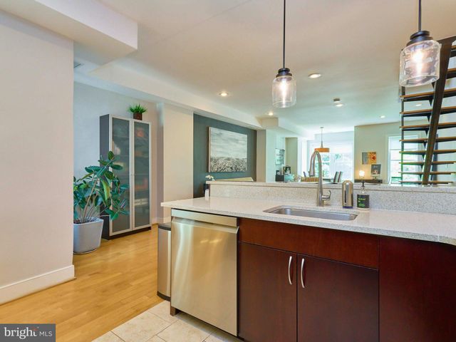 a kitchen with stainless steel appliances granite countertop a sink a counter space and a window