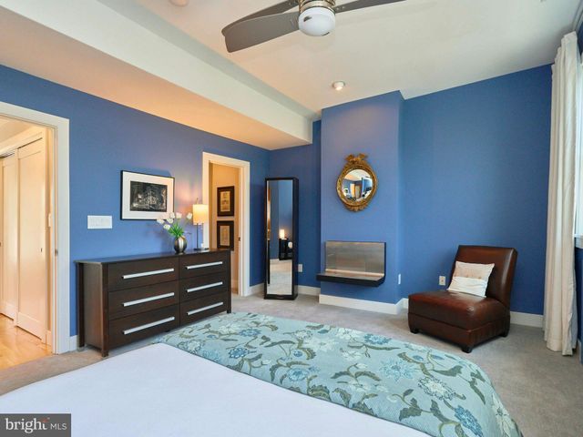 a bedroom with a bed and a lamp on dresser