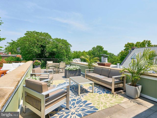 a view of a patio with couches potted plants and ocean view