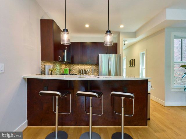 a kitchen with stainless steel appliances kitchen island granite countertop a table and chairs