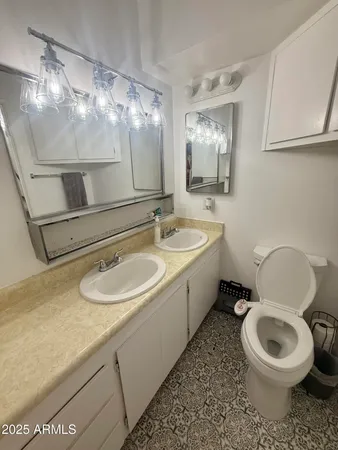 a bathroom with a sink a toilet and mirror