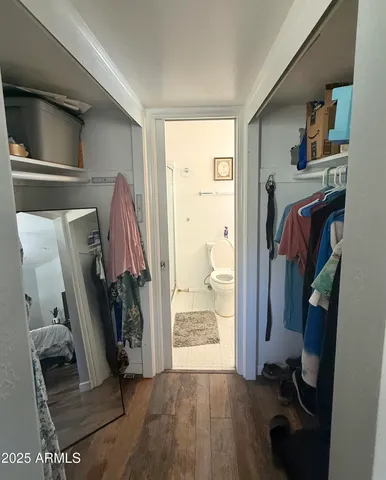 a view of walk in closet with clothes and shoes