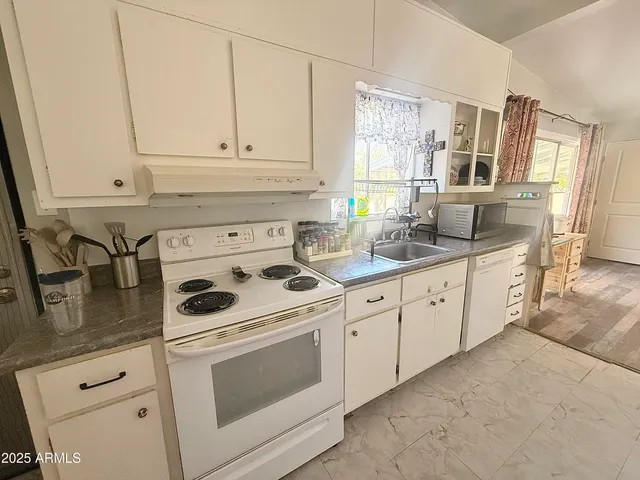 a kitchen with granite countertop white cabinets and white appliances