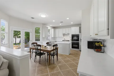 a kitchen with a dining table chairs and refrigerator