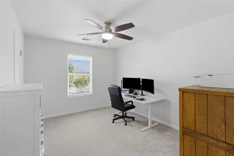 a view of a workspace with furniture and a window