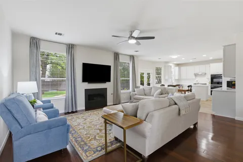 a living room with furniture a flat screen tv and a large window