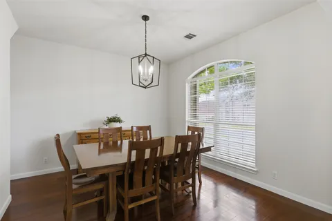 a view of a dining room with furniture wooden floor and chandelier