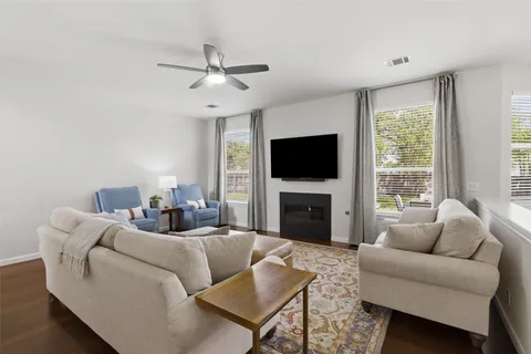 a living room with furniture a fireplace and a flat screen tv