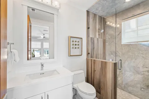 a bathroom with a granite countertop sink mirror and bathtub