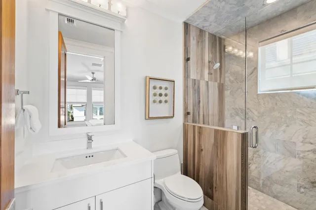 a bathroom with a granite countertop sink mirror and bathtub