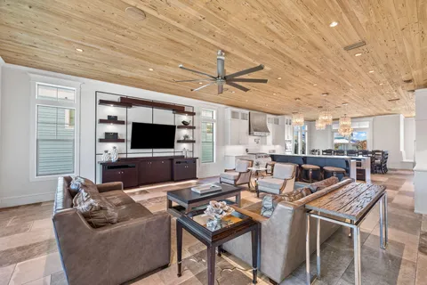 a dining hall with stainless steel appliances kitchen island granite countertop a table and chairs