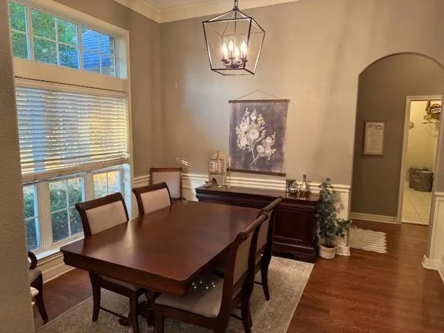 a view of a dining room with furniture a chandelier and wooden floor
