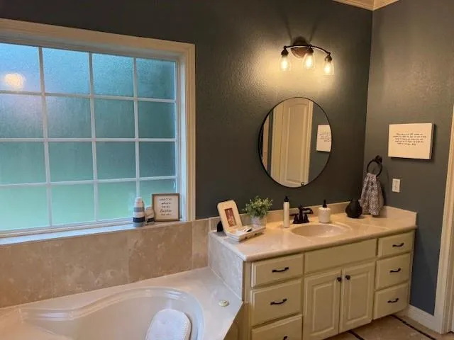 a bathroom with a sink mirror and tub
