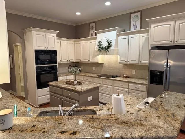 a kitchen with stainless steel appliances granite countertop a sink stove and refrigerator