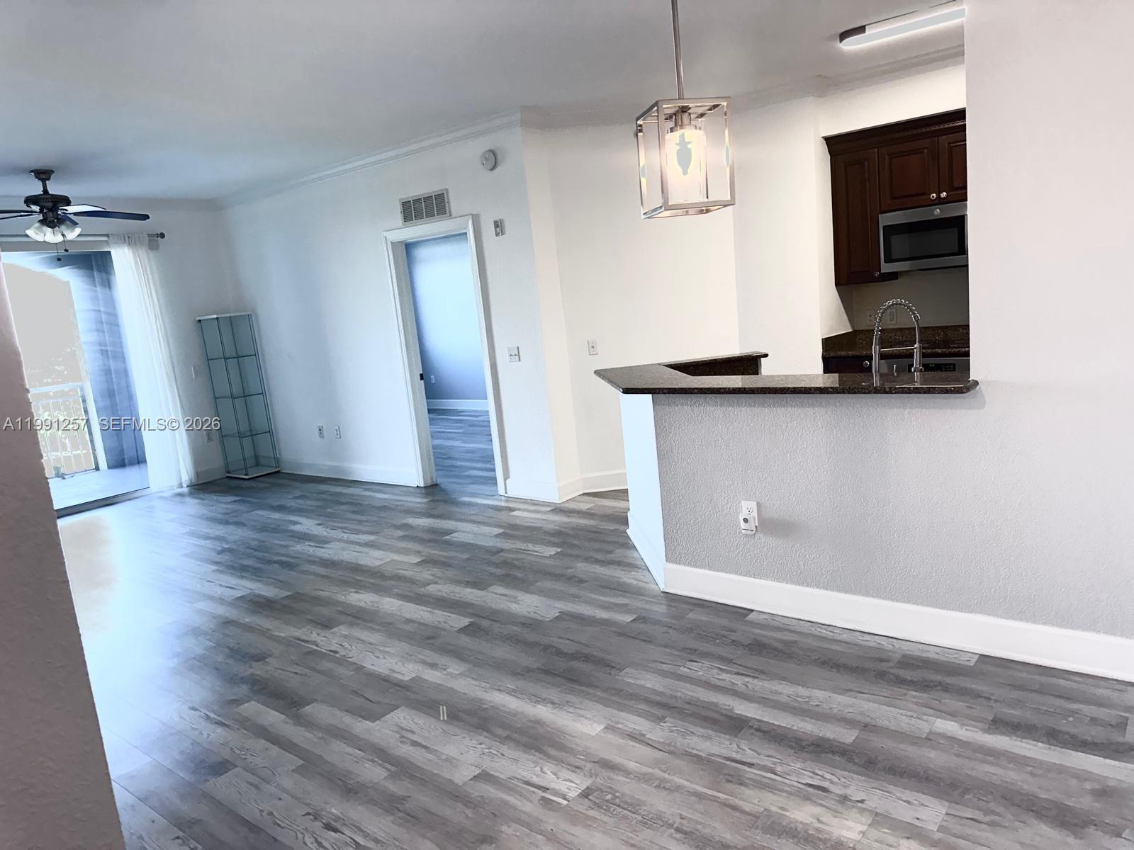 1660 Renaissance Commons Boulevard, Unit 2606 Boynton Beach, FL 33426 - Photo 7 of 26 a view of an empty room with wooden floor and a window
