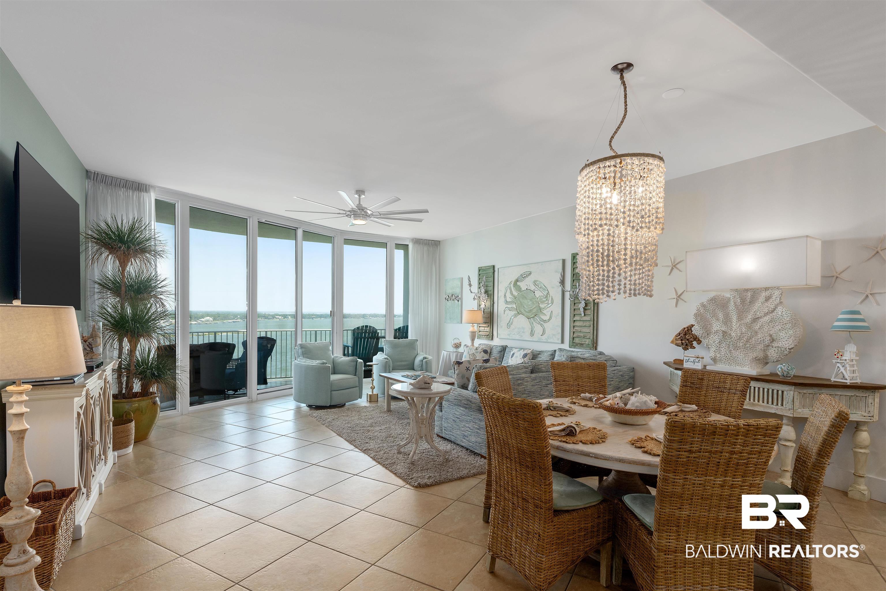 28107 Perdido Beach Boulevard, Unit DPH06 Orange Beach, AL 36561 - Photo 6 of 70 Dining area with light tile patterned floors, ceiling fan with notable chandelier, floor to ceiling windows, and a water view