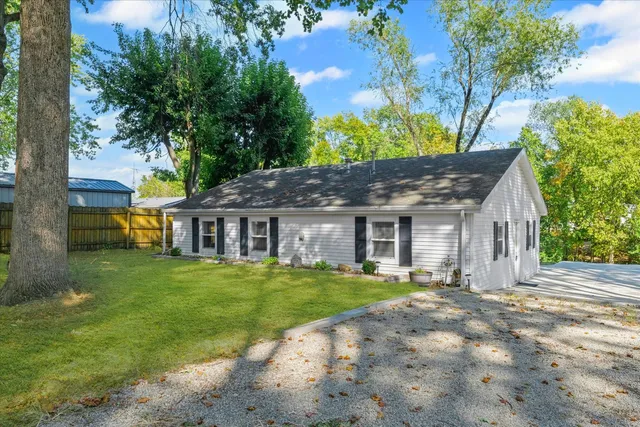 a view of a house next to a big yard with large trees