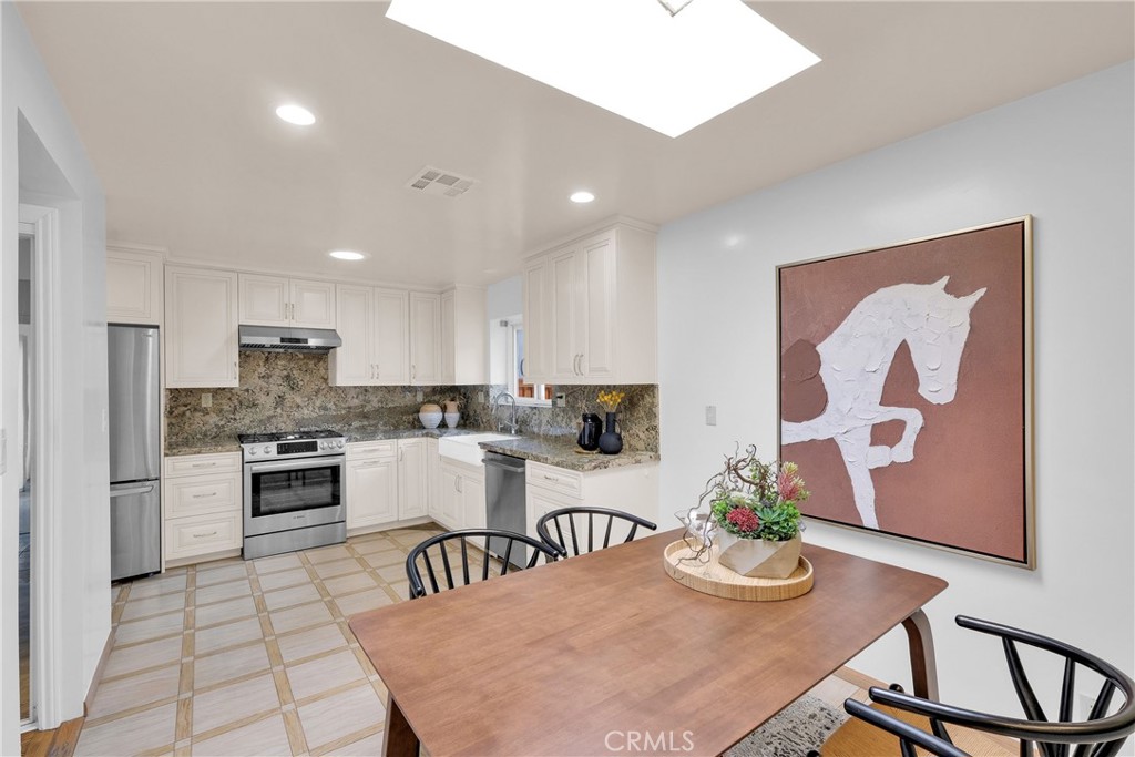 2395 Cooley Place Pasadena, CA 91104 - Photo 17 of 46 a kitchen with stainless steel appliances granite countertop a stove top oven a sink a dining table and chairs with wooden floor