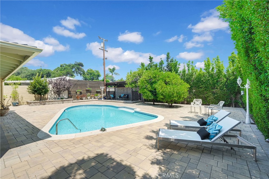 2395 Cooley Place Pasadena, CA 91104 - Photo 31 of 46 a view of a swimming pool with lawn chairs under an umbrella