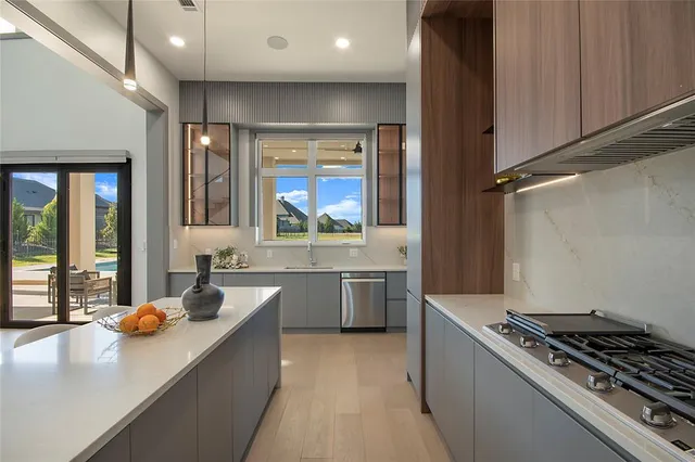 a kitchen with kitchen island a refrigerator and a sink