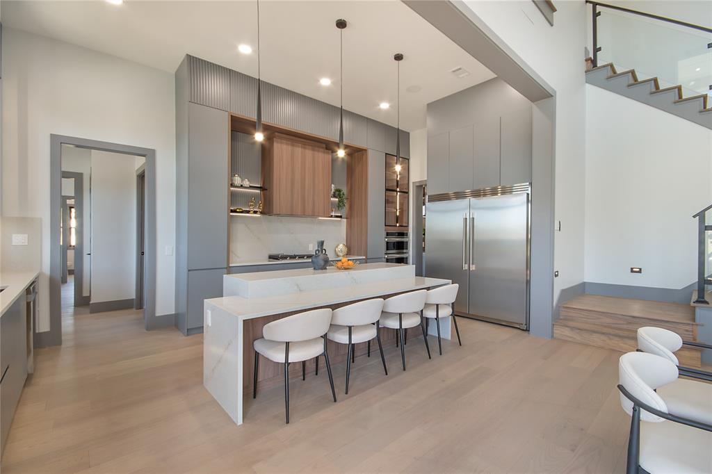 421 Sunrise Ridge Drive Heath, TX 75032 - Photo 7 of 39 a kitchen with kitchen island a refrigerator and a sink