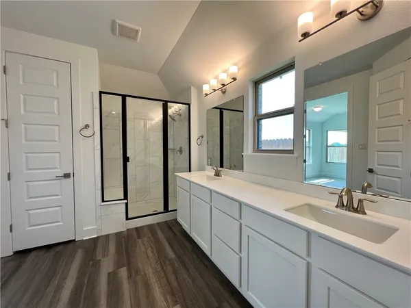 a spacious bathroom with a double vanity sink and a mirror