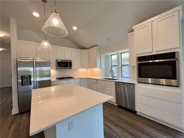 a kitchen that has a lot of cabinets and wooden floor