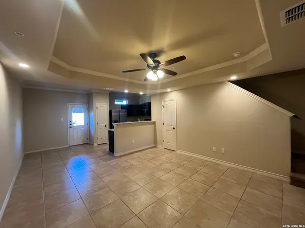 an empty room with a ceiling fan and carpet