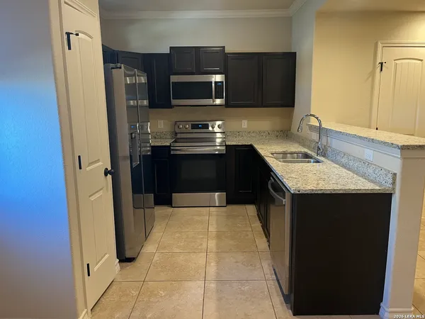 a kitchen with kitchen island granite countertop a sink and a stove