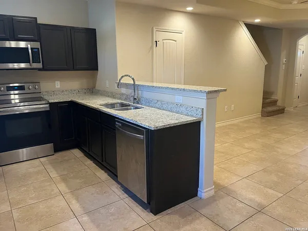 a kitchen with stainless steel appliances granite countertop a refrigerator and a sink
