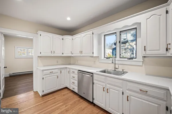 a kitchen with white cabinets and sink